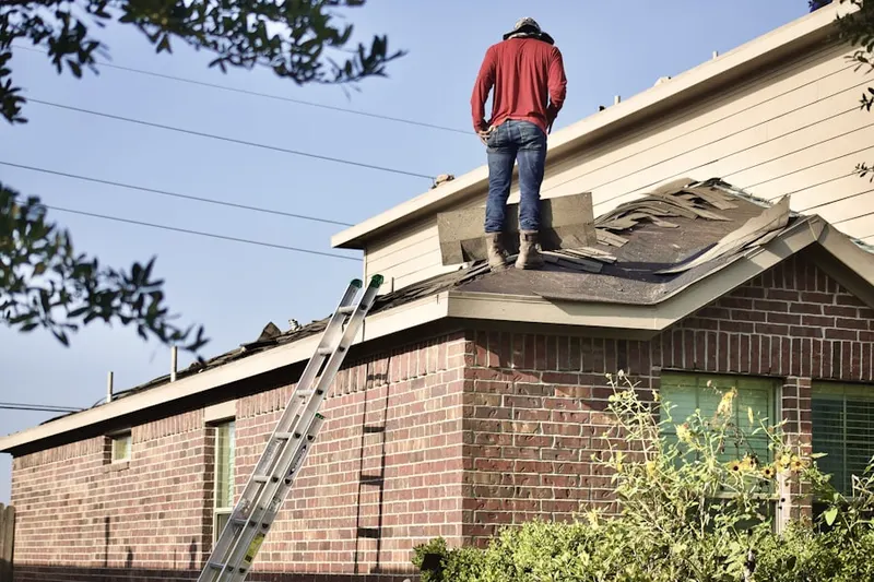 Professional roofer working on a residential roof in Holliston